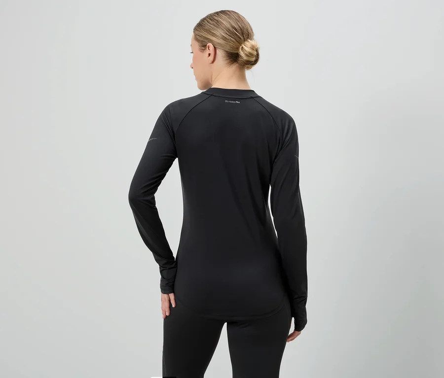 Hátulnézet egy szőke hajú nőről, aki fekete, hosszú ujjú sportfelsőt és leggingset visel.