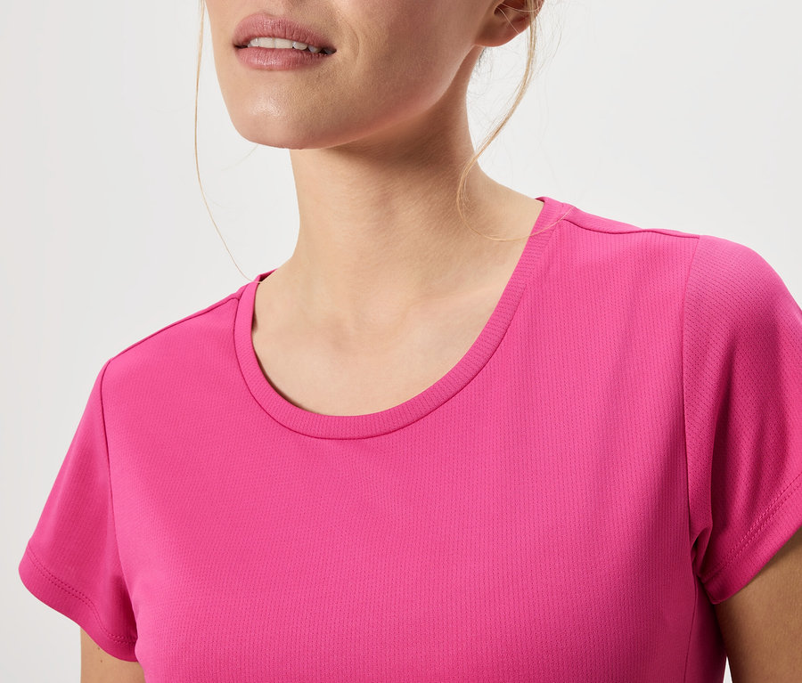 Közeli kép egy rózsaszín pólót viselő nőről.