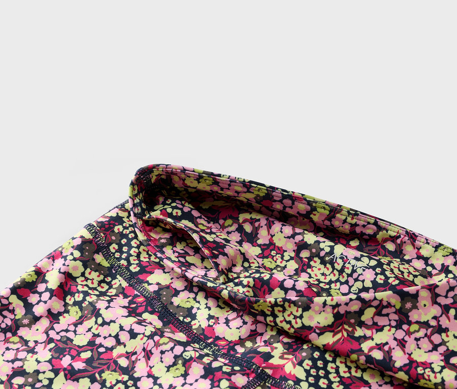 Virágos leggings közeli képe sötétkék derékpánttal és oldalzsebbel.