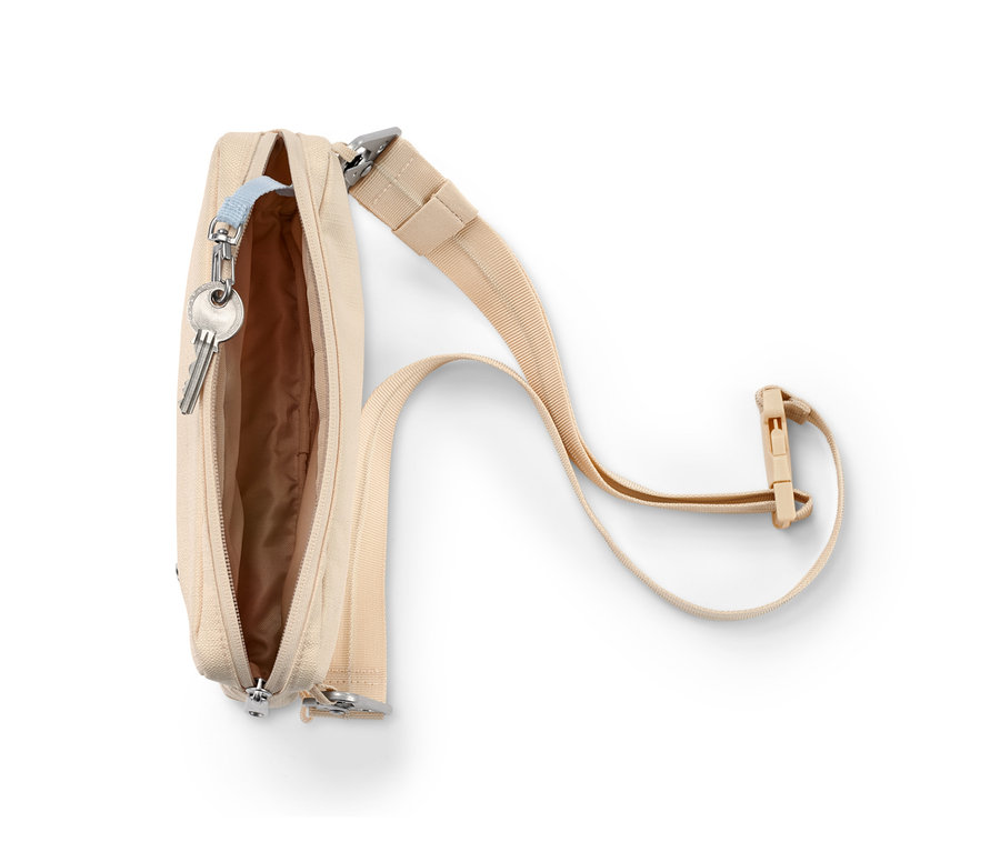 Nyitott bézs biztonsági oldal- és övtáska kulcsokkal.