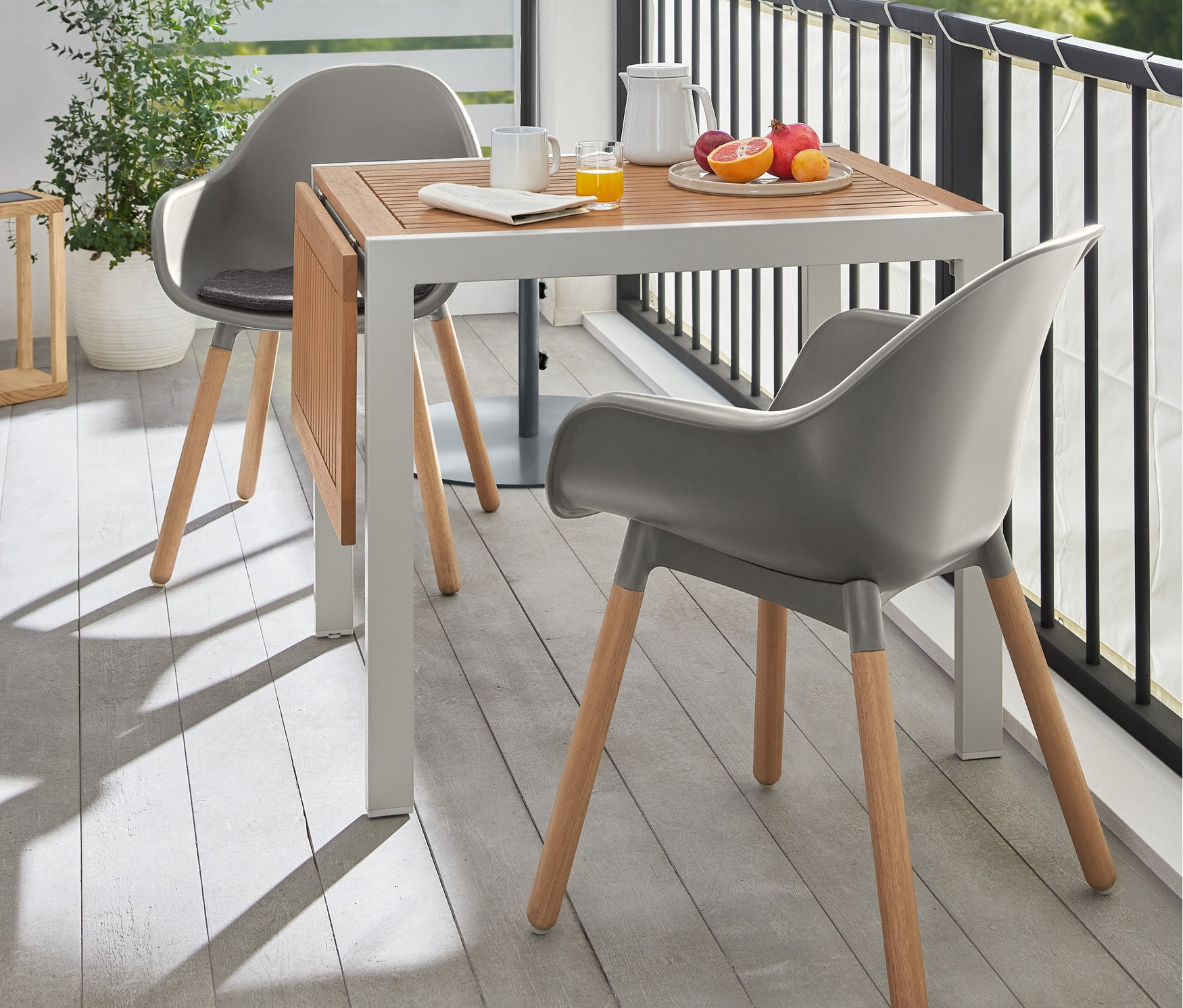 Két szürke kerti kagylószék áll egy kerti asztal, felnyitható, alumínium lábak, "Liska" asztalnál a teraszon.