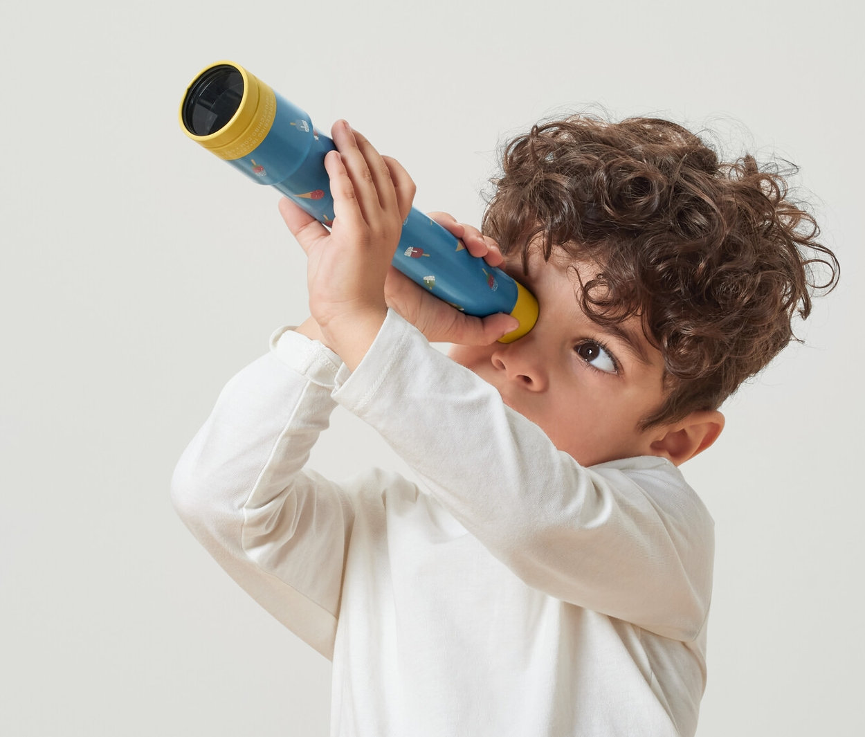 Fiú néz át egy játék távcsövön.