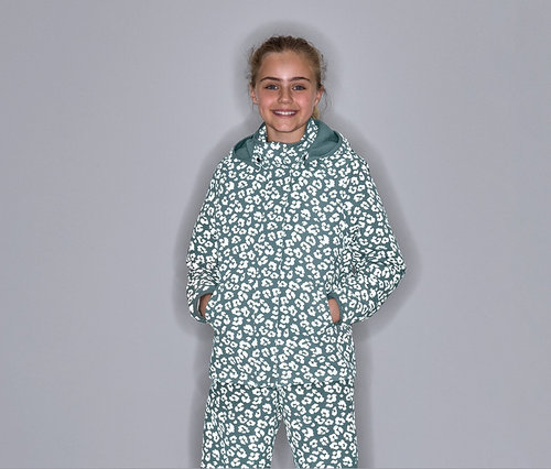 Lány pózol hőálló esőkabátban, fényvisszaverő elemekkel és leopárdmintával.