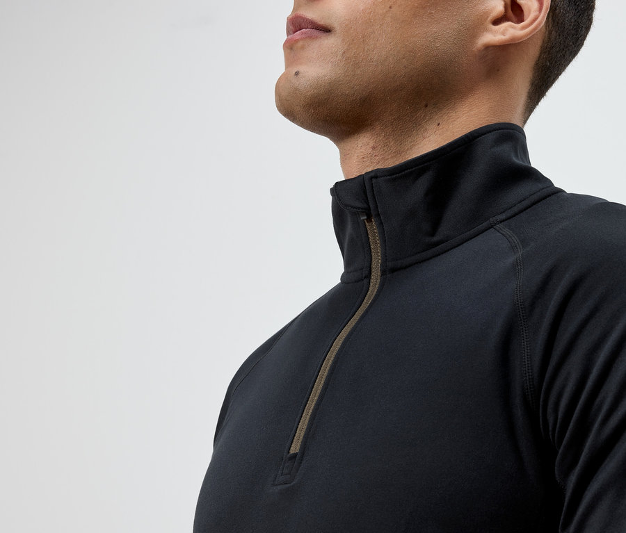 Férfi visel egy fekete, hosszú ujjú, cipzáras pólót.