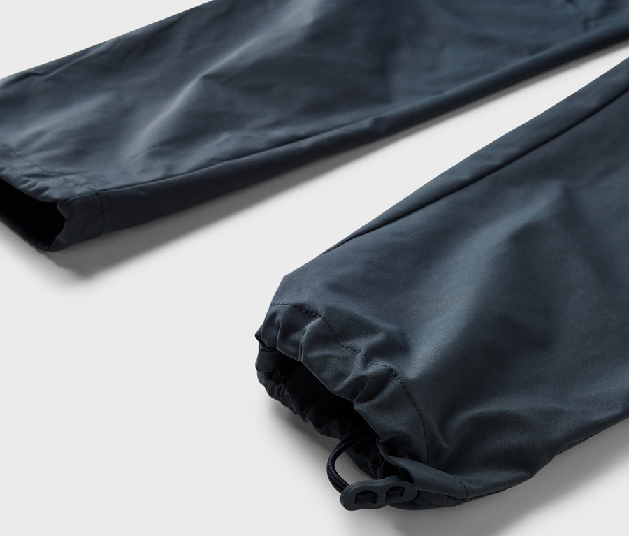 Egy sötétkék, 2 az 1-ben funkcionális nadrág részlete.