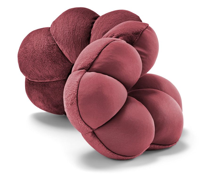 Közeli kép egy borvörös, virág alakú párnáról.