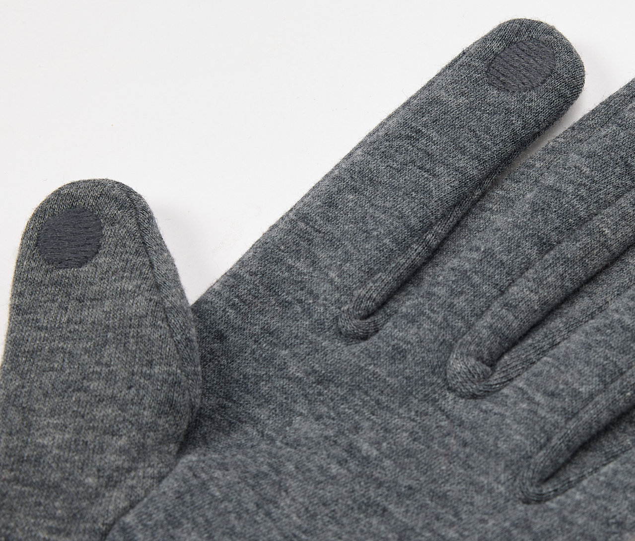 Egy szürke kesztyű közeli képe érintőképernyő-kompatibilis ujjbeggyel.