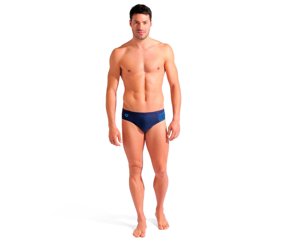 Egy férfi áll és arena márkájú Scratchy tengerészkék úszónadrágot visel.