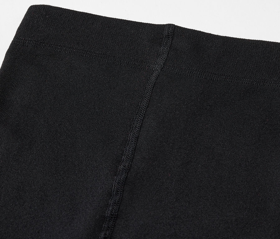 Közeli felvétel egy fekete leggings felső részéről, látható varrással.