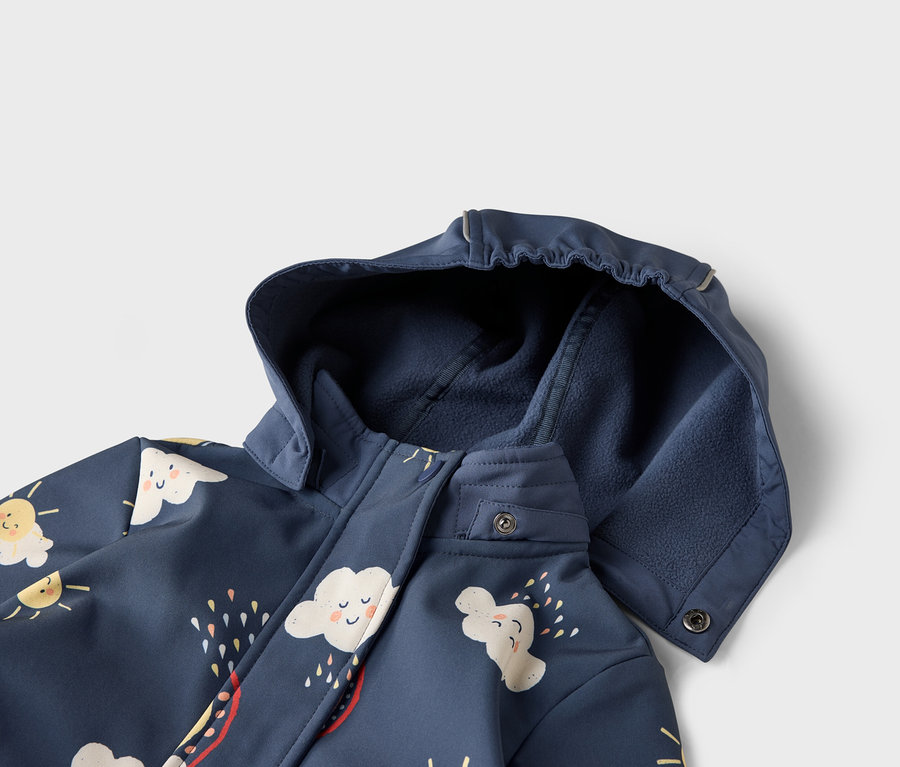 Egy sötétkék, kapucnis kabát részletgazdag képe, felhő- és napmintákkal díszítve.