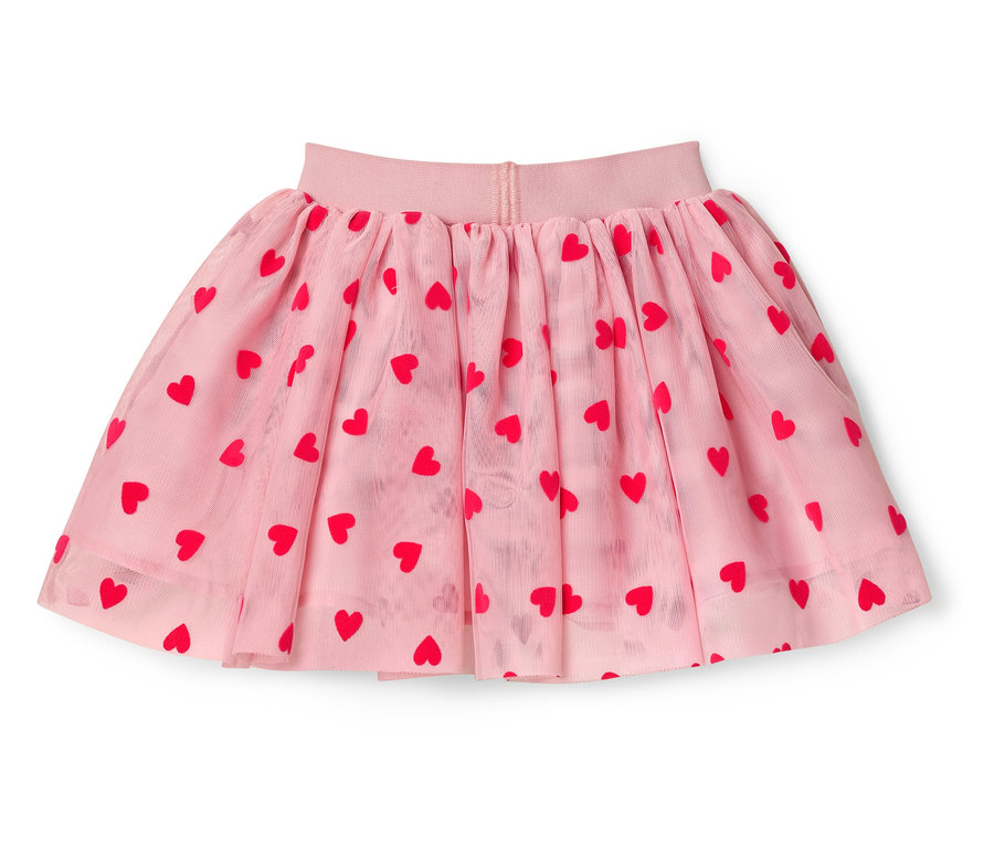 Egy rózsaszín tüllszoknya piros szívekkel egy fehér háttéren.