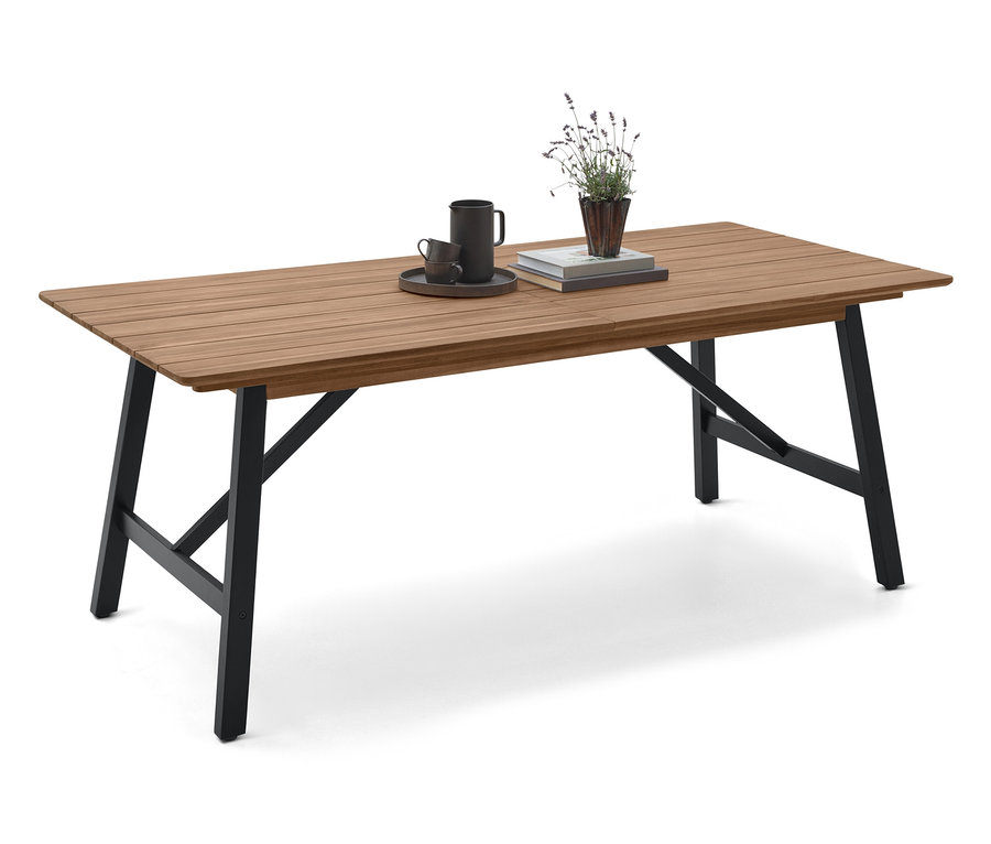 Egy fekete lábú fa asztalon egy csésze, egy csészealj, egy könyv és egy növény található.