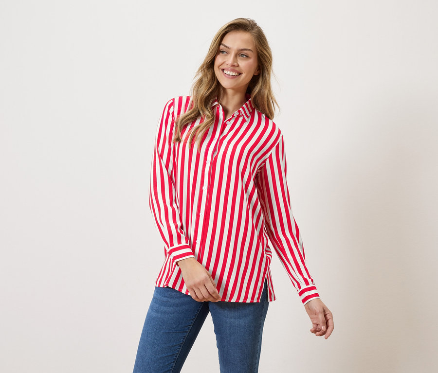 Nő visel piros-fehér csíkos inget és farmert.