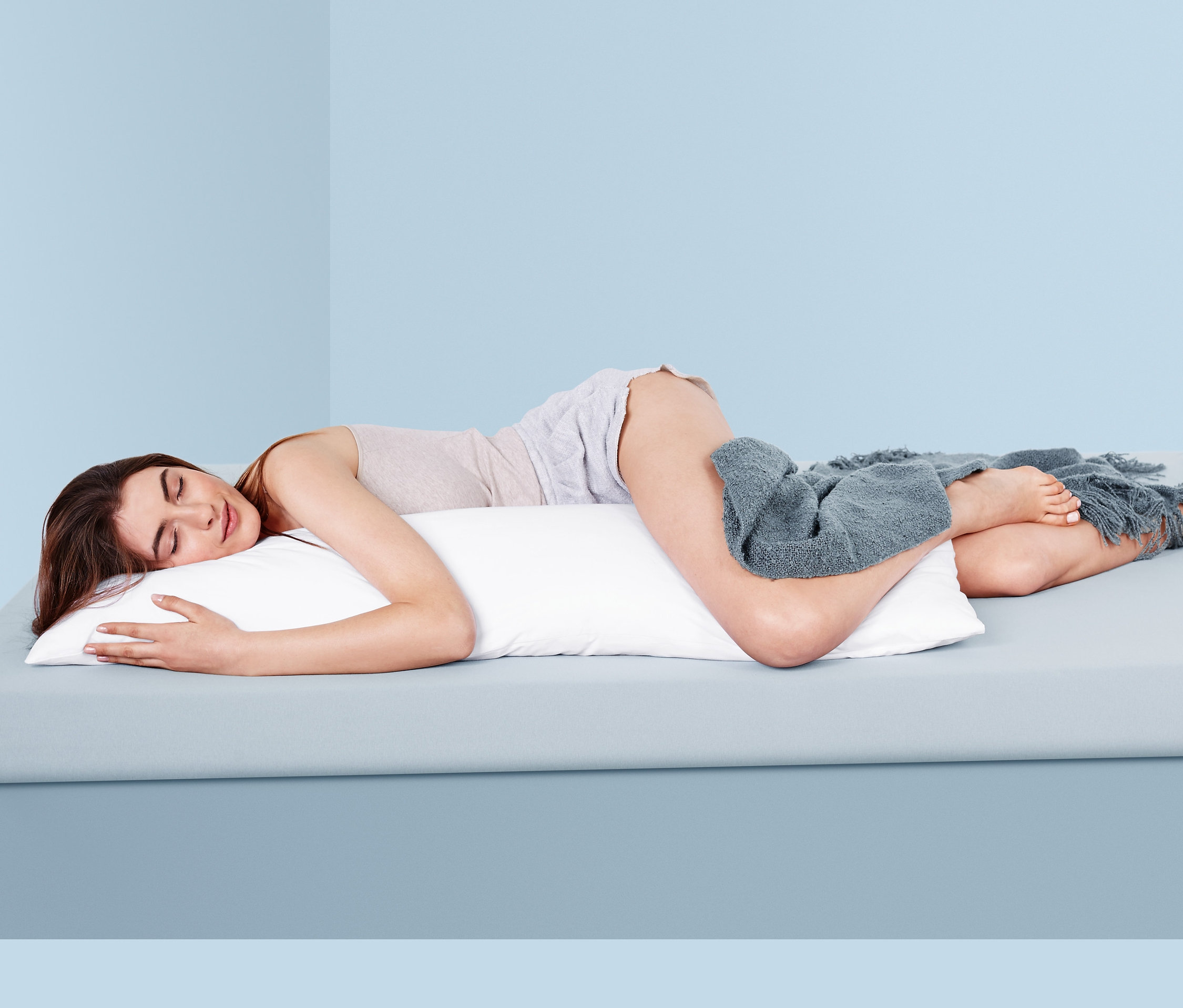 Nő oldalt alszik egy párnán oldalt alvóknak.