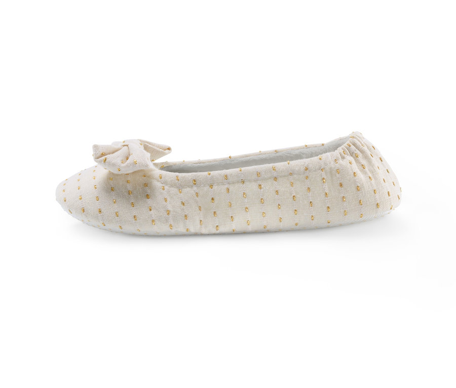 Egy bézs, pöttyös női házicipő masnival.