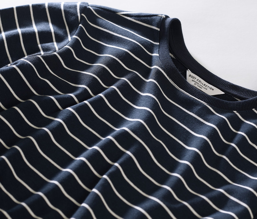 Egy csíkos női pizsama leggingsszel részletének közeli képe.