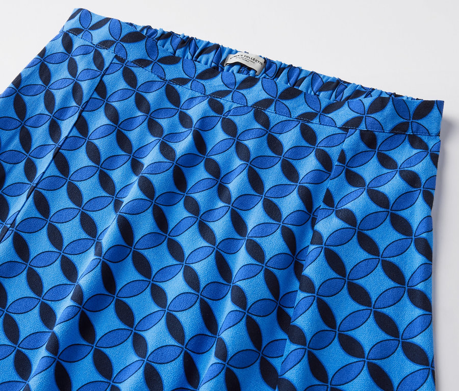 Egy sötétkék, mintás midiszoknya részlete geometrikus mintával.