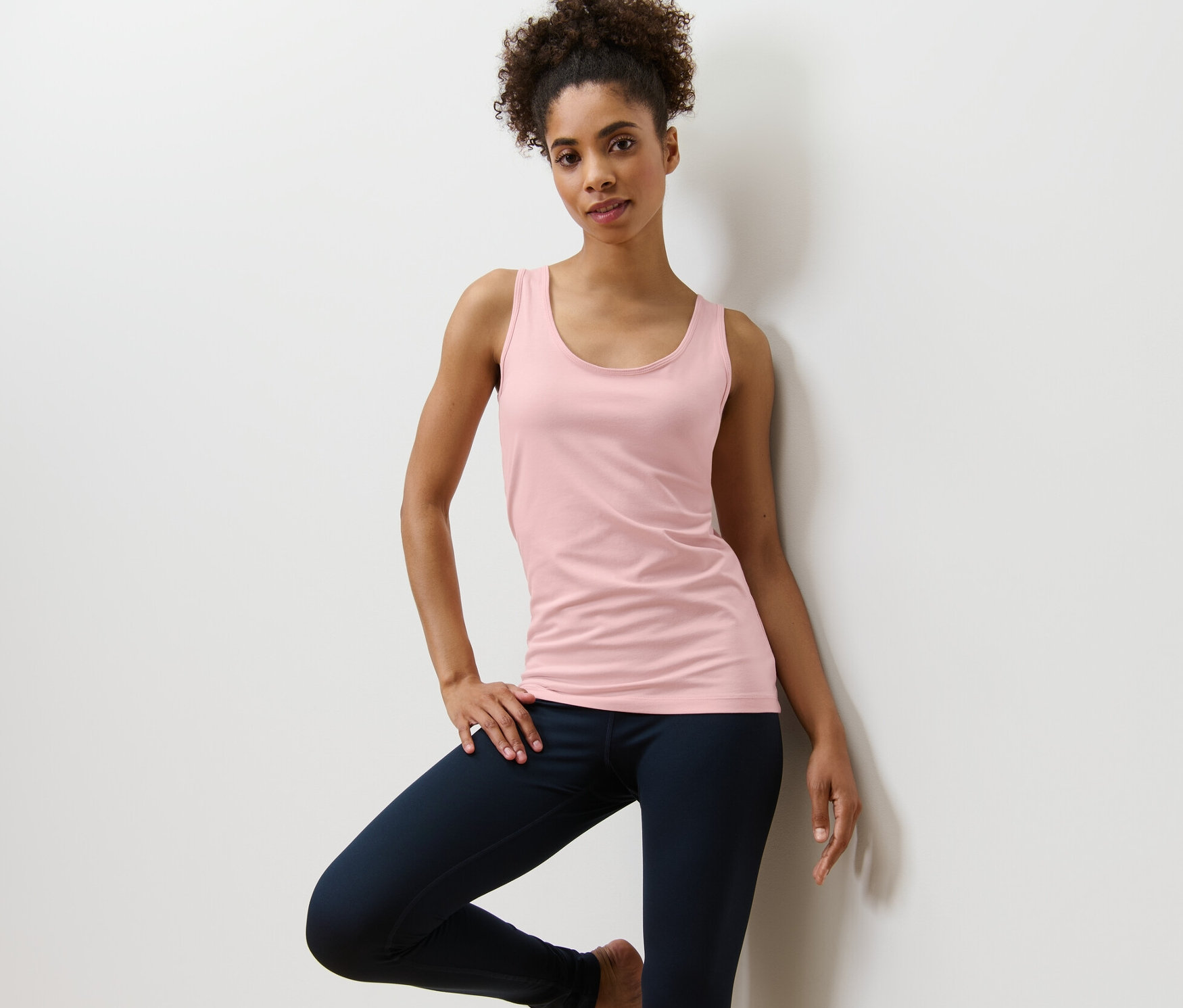 Nő pózol egy rózsaszín női toppban egy 2 darabos szettből.