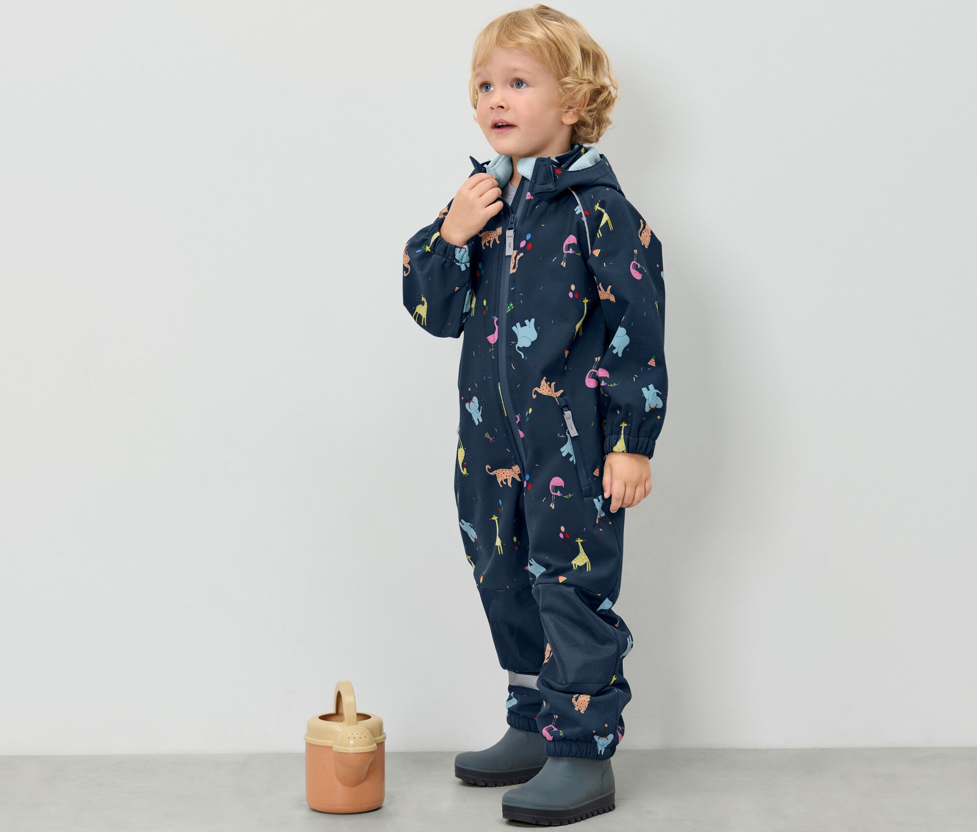 Fiúgyermek gyermek softshell kezeslábasban, állatmintás.
