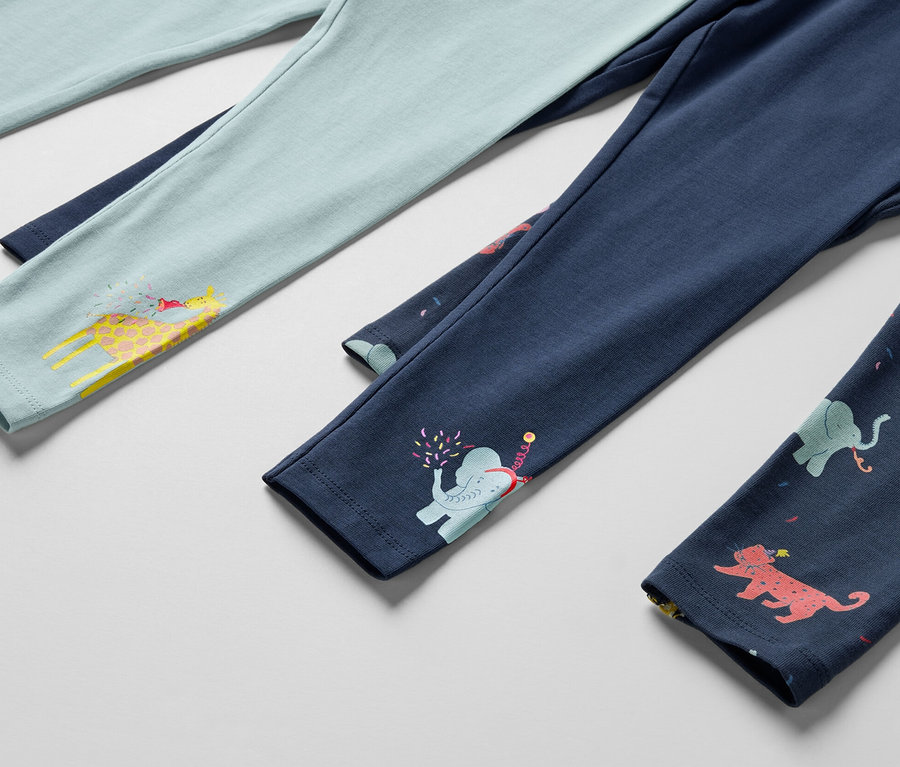 Három gyerek leggings részlete, egy világoskék zsiráfos, egy sötétkék elefántos és egy sötétkék állatos.
