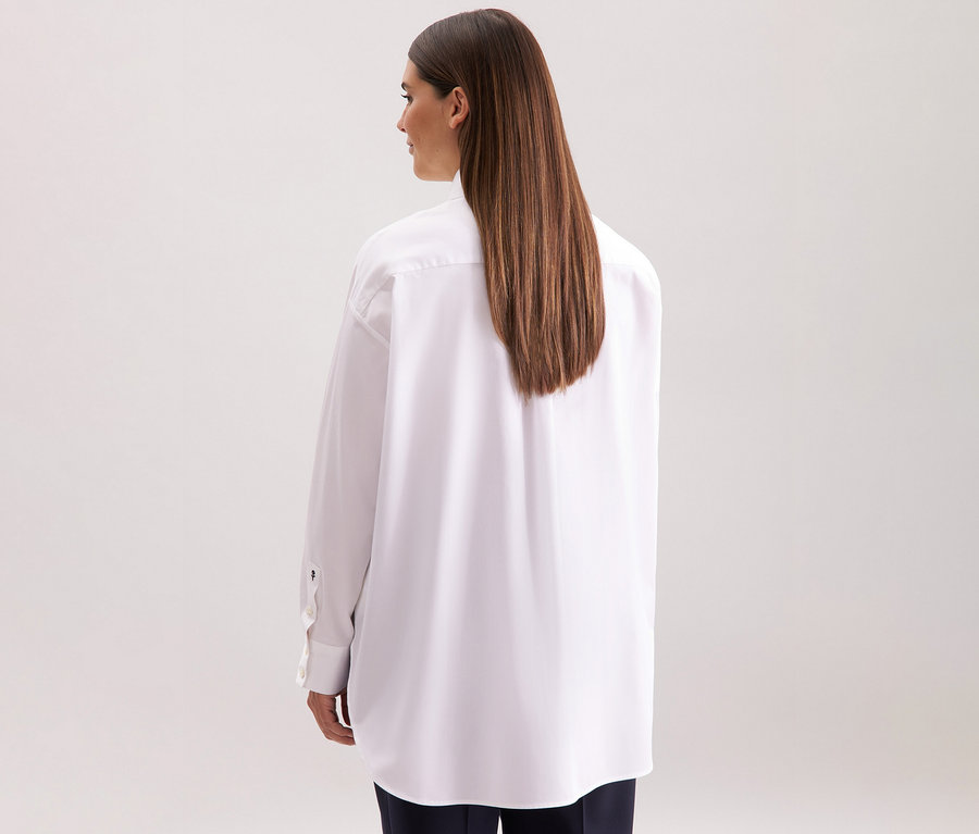 Hátulról látható nő fehér Seidensticker túlméretes hosszú ingblúzban.