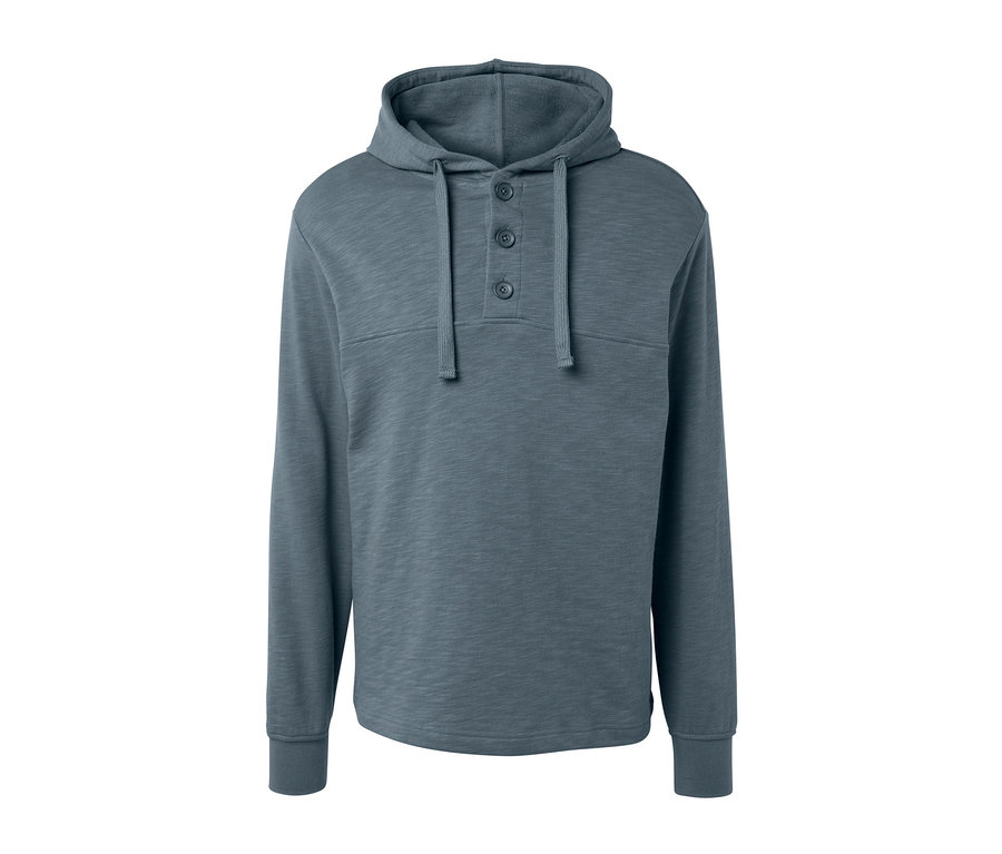 Egy szürke, gombos kapucnis pulóver.