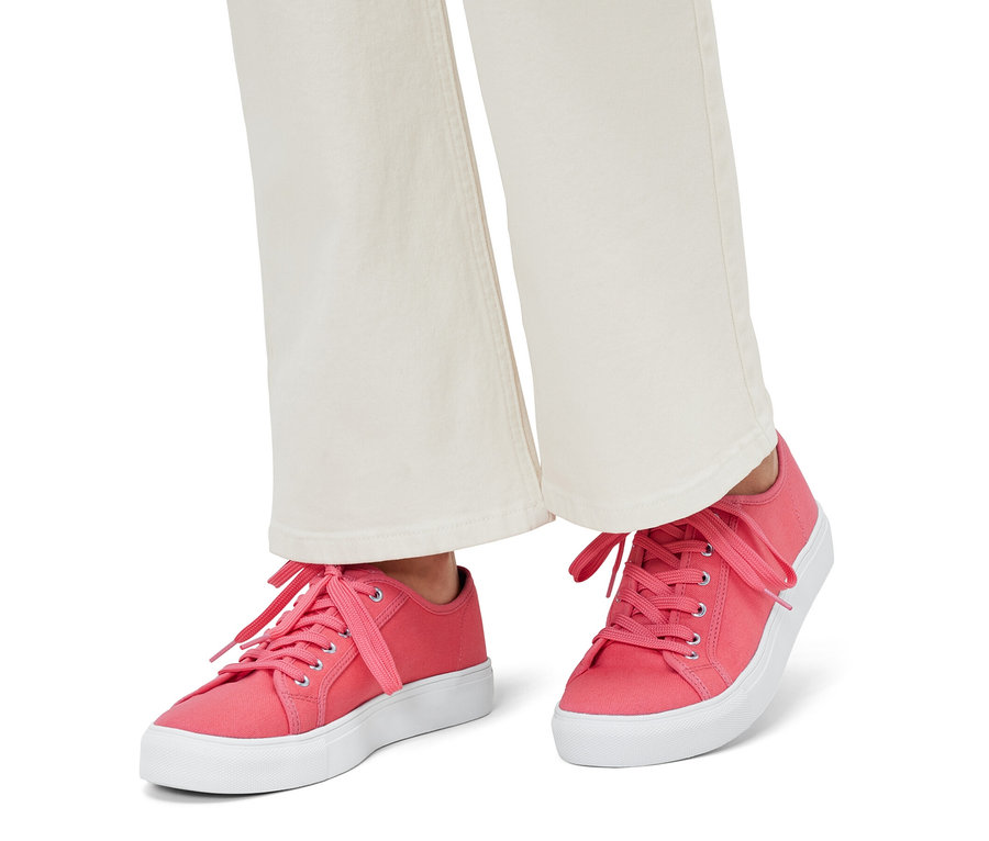 Lábak vászon sneaker cipőben.