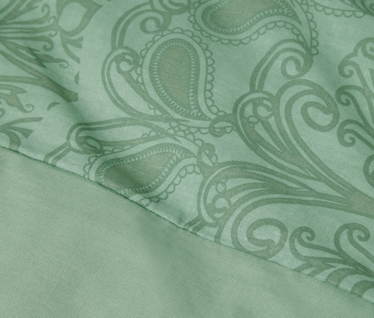 Közelkép egy zöld, mandalás mintázatú, normál méretű renforcé ágyneműről.