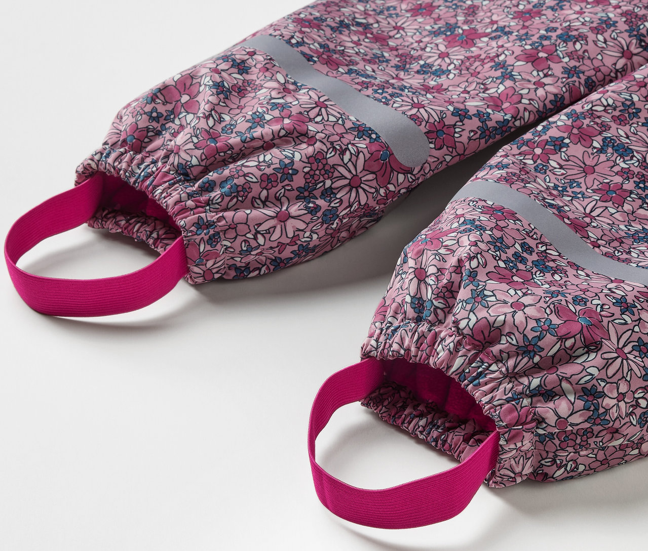 Egy virágmintás, fényvisszaverő elemekkel ellátott gyerek termo esőnadrág részlete.