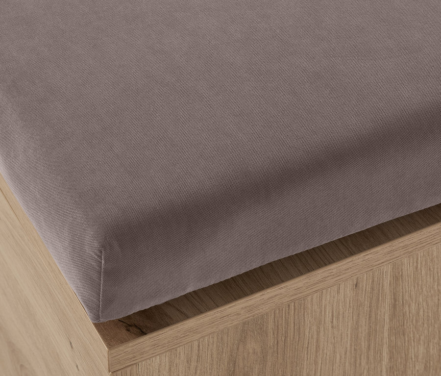 Egy szürke, tárolóval ellátott pad részlete.