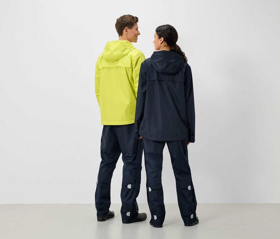 Egy férfi és egy nő háttal állnak egymásnak, esőkabátot és nadrágot viselnek.