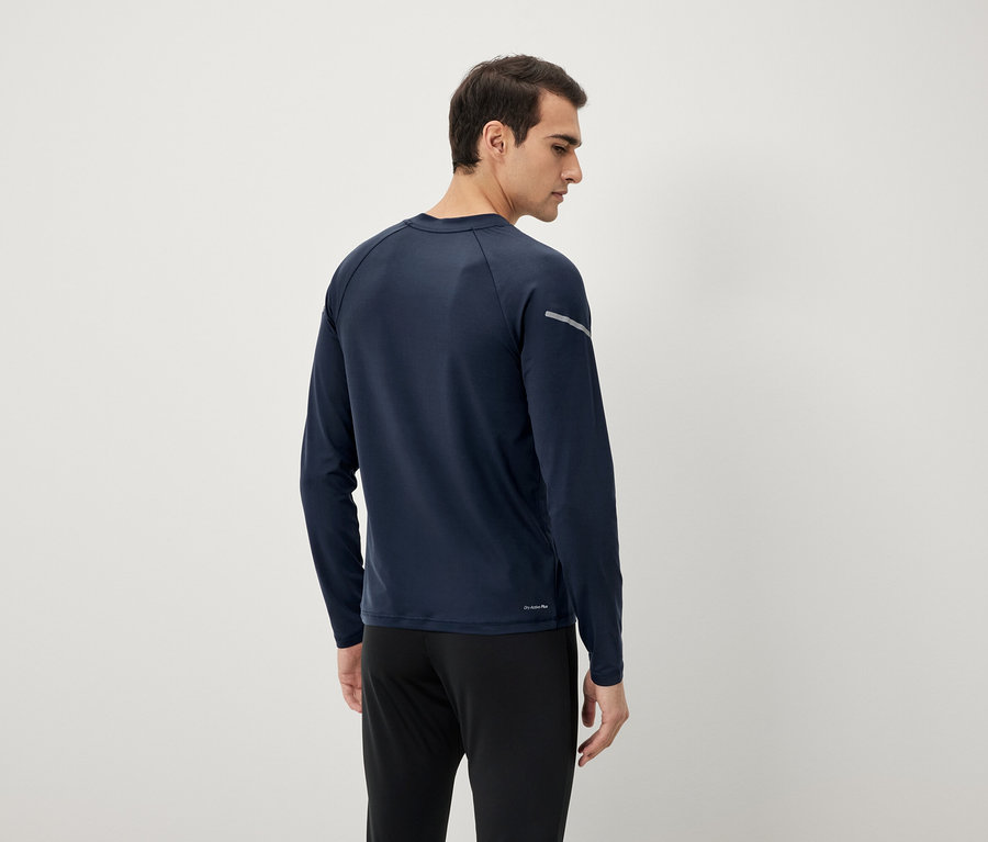 Hátulról látható férfi sötétkék hosszú ujjú felsőben és fekete nadrágban.