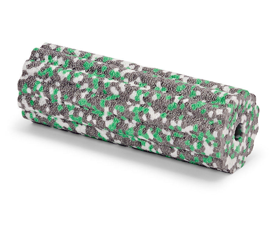 Egy zöld, szürke és fehér mintás habszivacs henger fekszik egy fehér felületen.