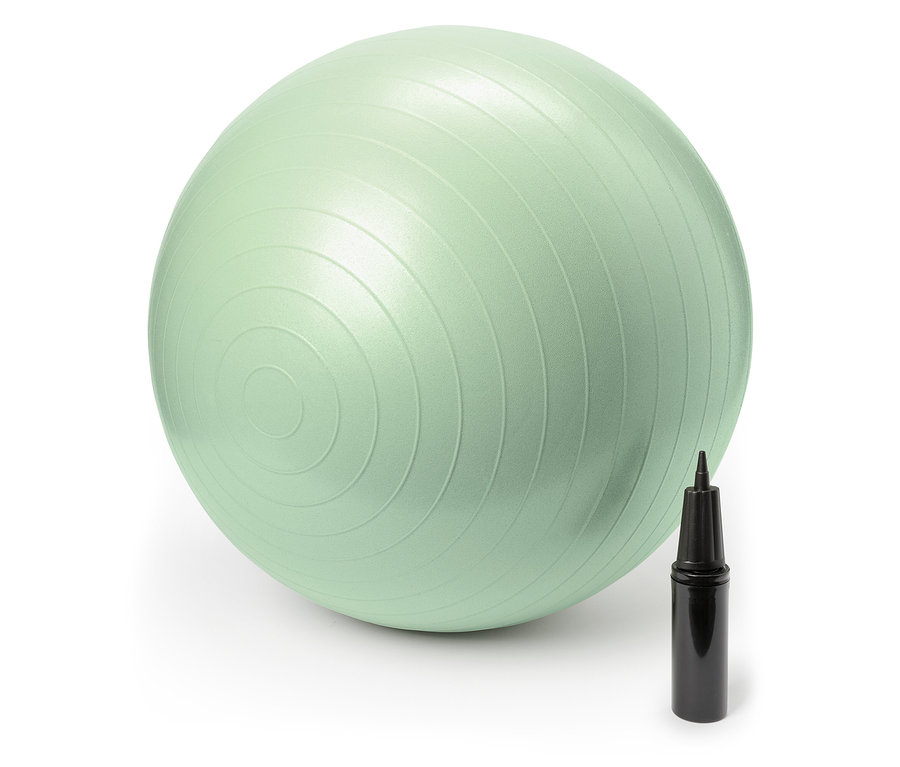 Egy pasztellzöld gimnasztikai labda egy fekete kézi pumpa mellett áll.