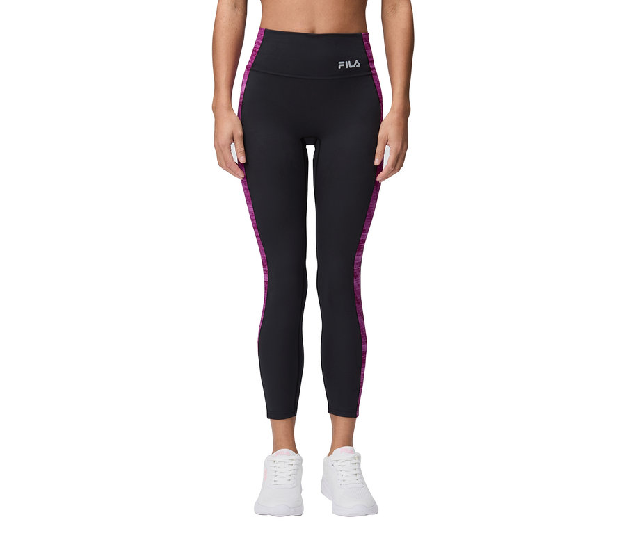 Egy nő fekete Fila leggings-et visel lila csíkokkal és fehér sportcipőt.