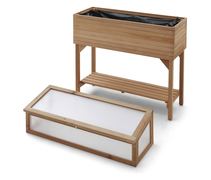 Egy fából készült magaságyás virágládával a lábán és egy üvegház átlátszó tetővel.