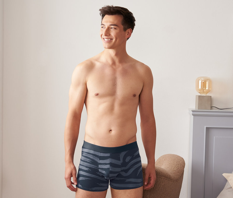 Férfi a 2 darabos férfi boxer alsónadrág szett egyikét viseli.