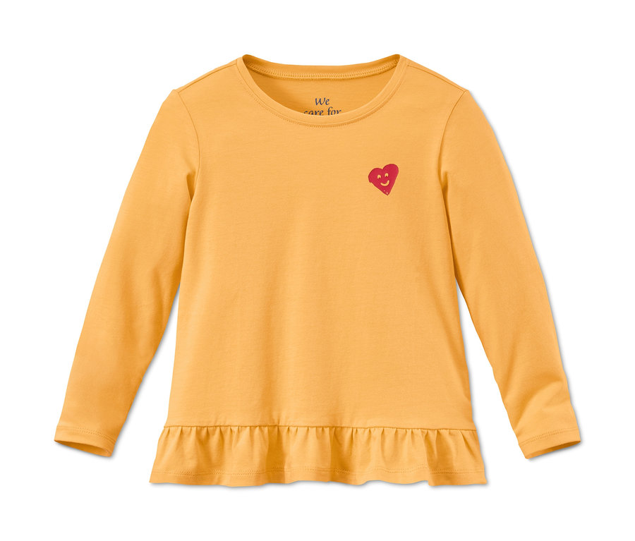 Egy hosszú ujjú, sárga bio pamut póló, piros szívvel és fodrokkal.