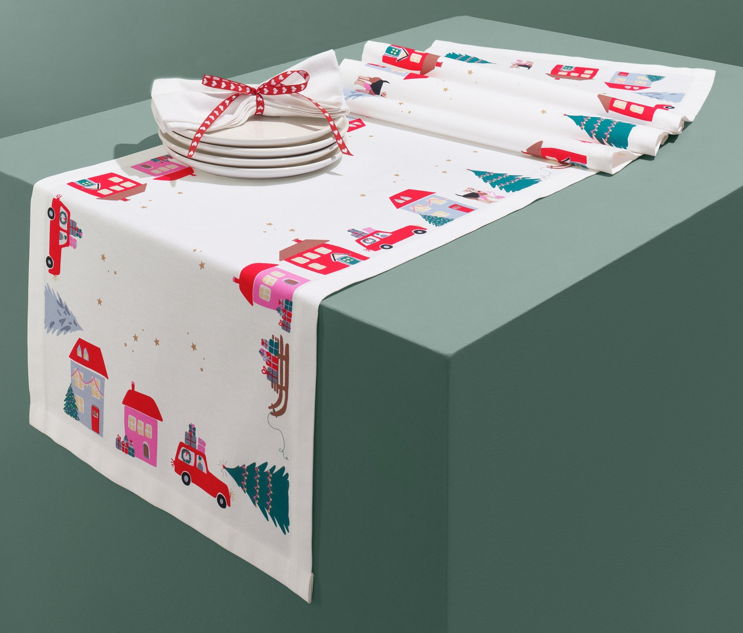 Asztali futó karácsonyi mintával, házakkal és autókkal.