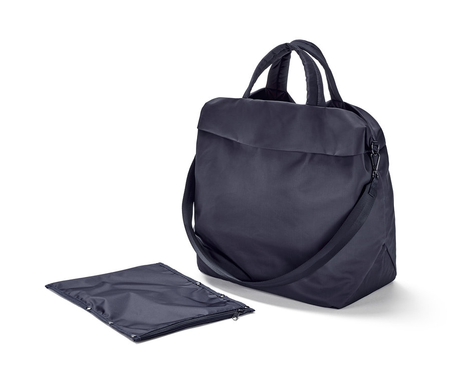 Sötétkék sporttáska fogantyúkkal és vállpánttal egy összehajtott sötétkék táska mellett.