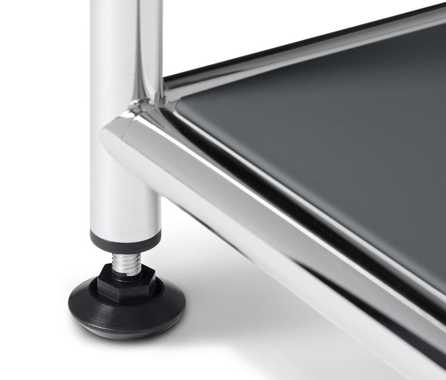 A szürke fém dohányzóasztal részlete krómozott lábbal és fekete talppal.