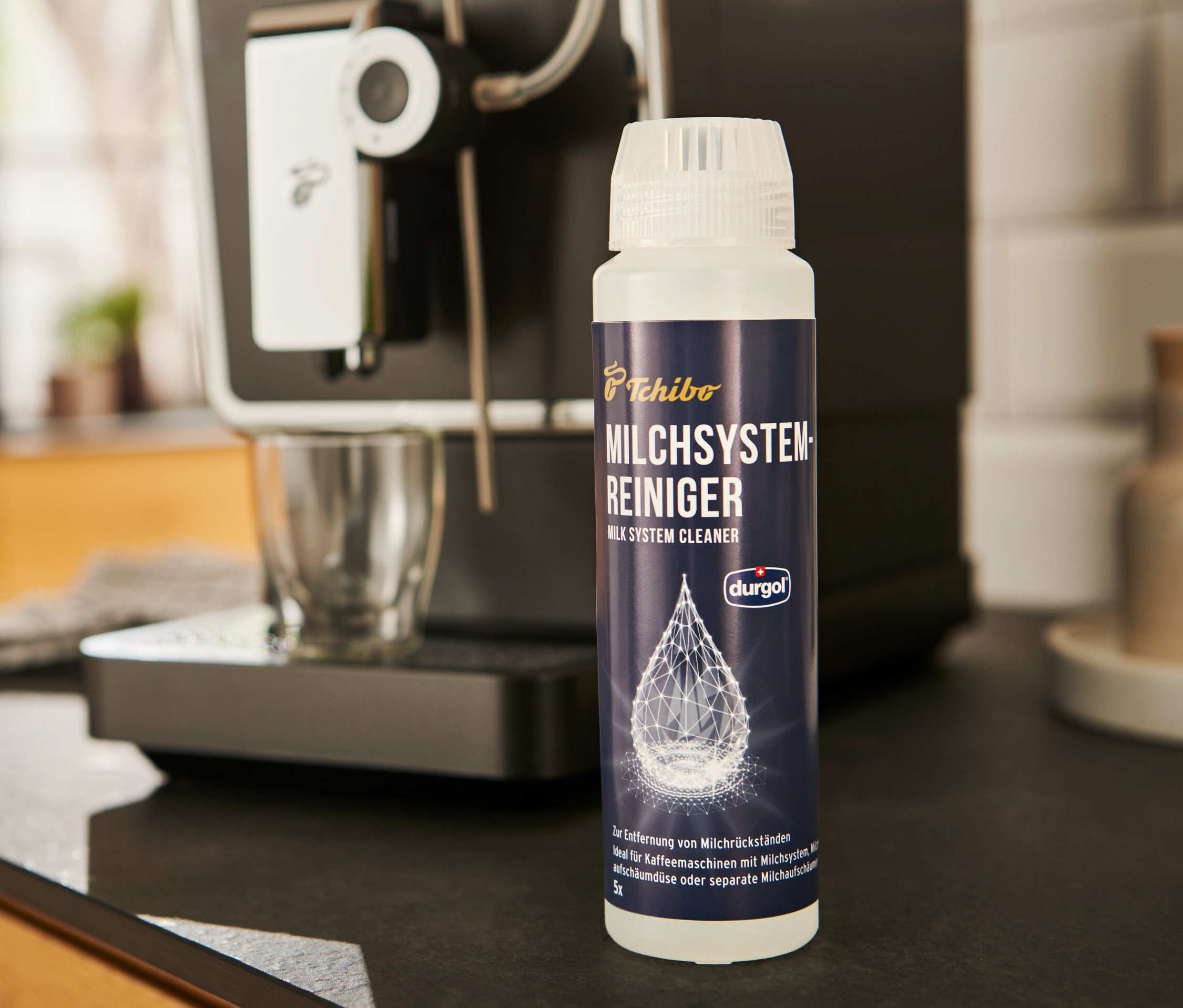 A durgol® tejrendszer tisztító	, 250 ml egy kávéfőző mellett áll.