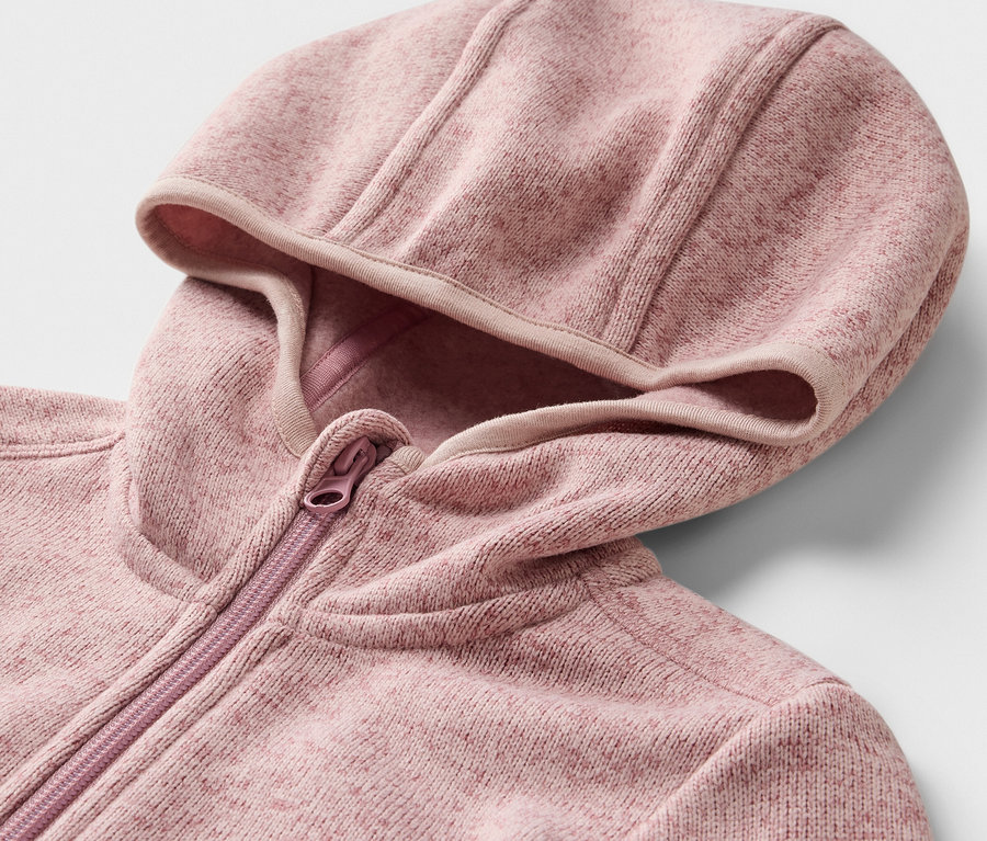 Egy kötött polár felső részletének képe, kapucnival és cipzárral.