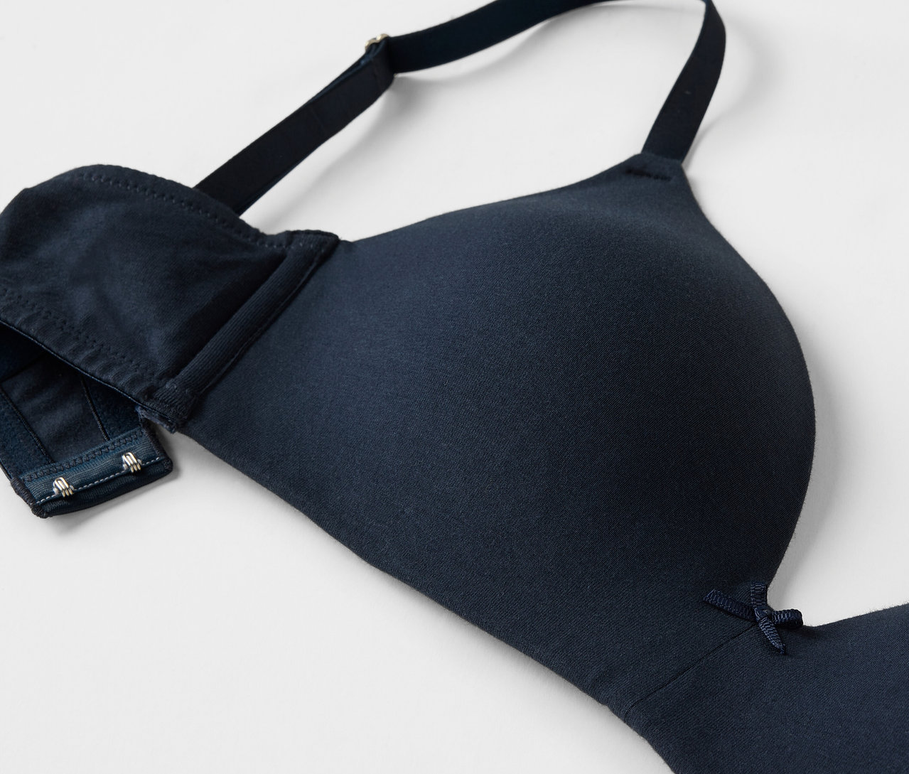 Közeli kép egy sötétkék melltartóról, állítható pántokkal és kapcsos zárással.