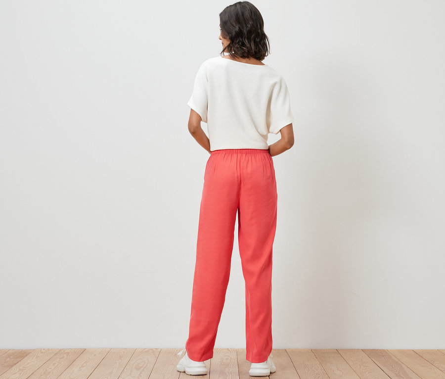 Nő szőtt nadrágot és felsőt visel.