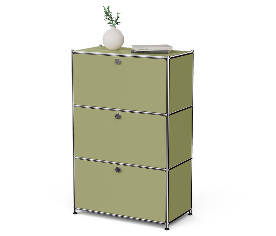 Egy zöld szekrény három fiókkal, tetején egy váza növénnyel és egy könyv.