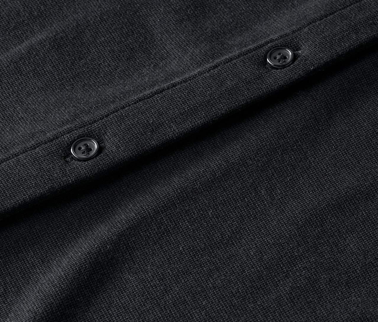 Fekete, gombos kardigán részlete.