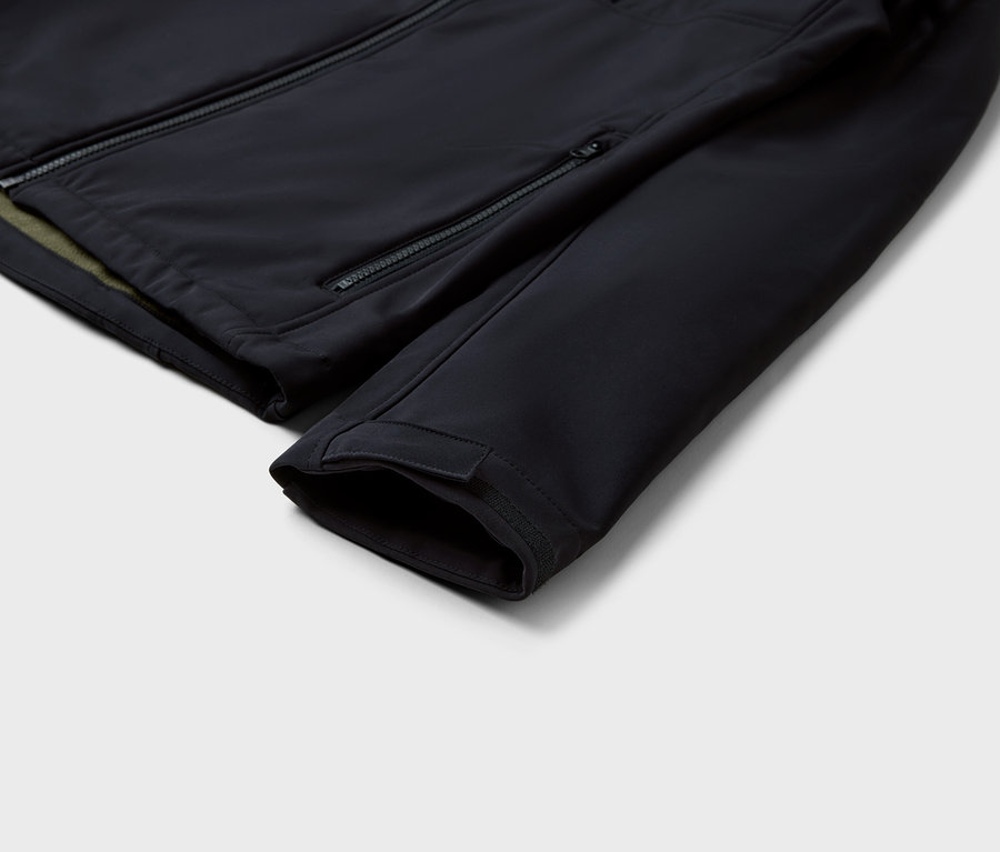 Egy fekete kabát részlete cipzárakkal és ujjal.