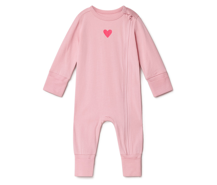 Rózsaszín baba overál piros szívvel a mellkasán és oldalsó cipzárral.