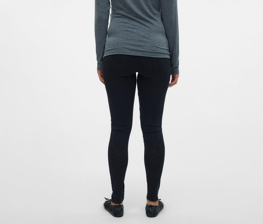 Hátulnézet egy szürke felsőt és 2 db MAMALICIOUS kismama leggingset viselő nőről.